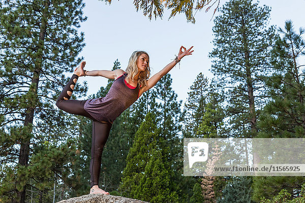 Junge Frau beim Yoga auf einem Felsen; Kalifornien,  Vereinigte Staaten von Amerika'.