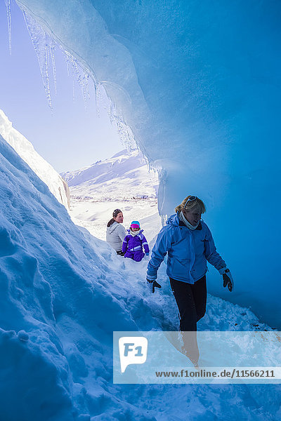 Eine Familie erkundet eine kleine Gletscherspalte im Worthington Glacier in der Nähe des Thompson Pass; Alaska  Vereinigte Staaten von Amerika'.