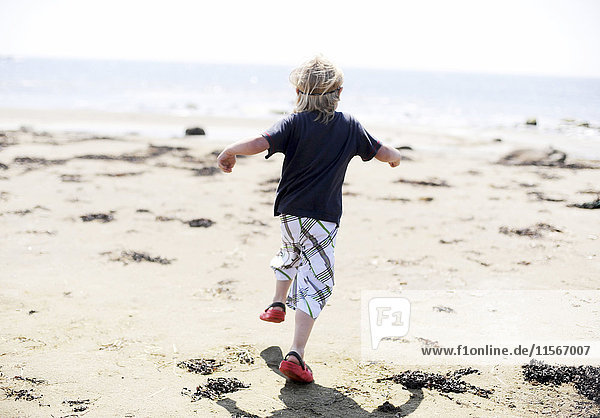 Junge läuft am Strand