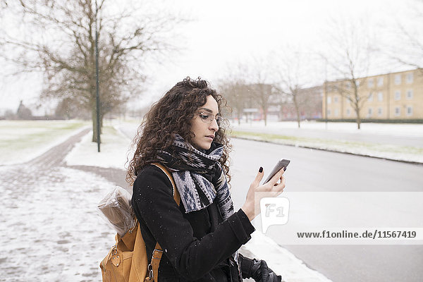 Woman waiting and looking at her phone