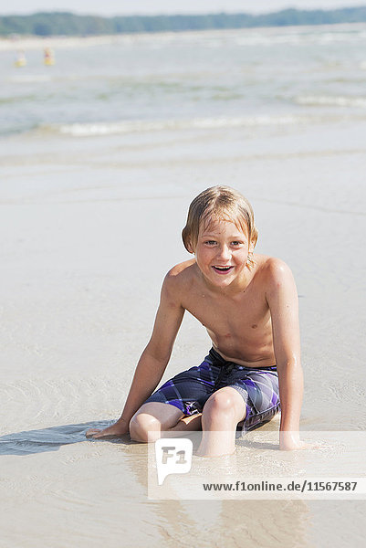 Smiling boy on sandy beach