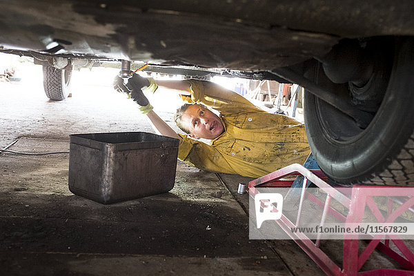 Woman mechanic repairing vintage car