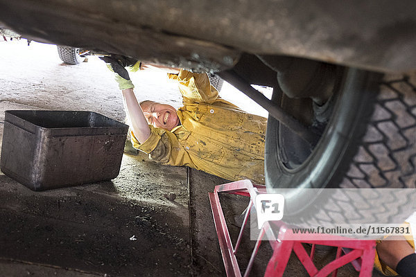 Woman mechanic repairing vintage car