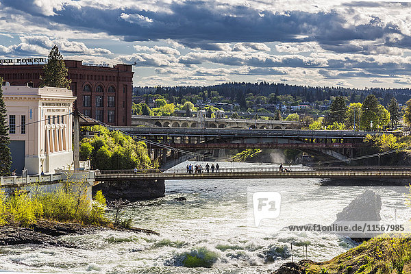 Menschen  die auf einer Fußgängerbrücke über den Spokane River gehen; Spokane  Washington  Vereinigte Staaten von Amerika'.