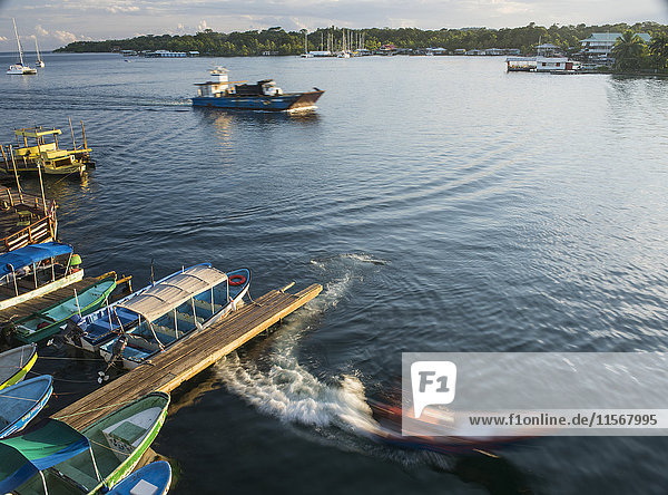 'A slow exposure of a water taxi leaving the dock and a landing craft hauling a dump truck from the Isla Colon back to the mainland; Bocas Town  Bocas del Toro  Panama'