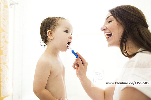 Mother brushing son (4-5) teeth