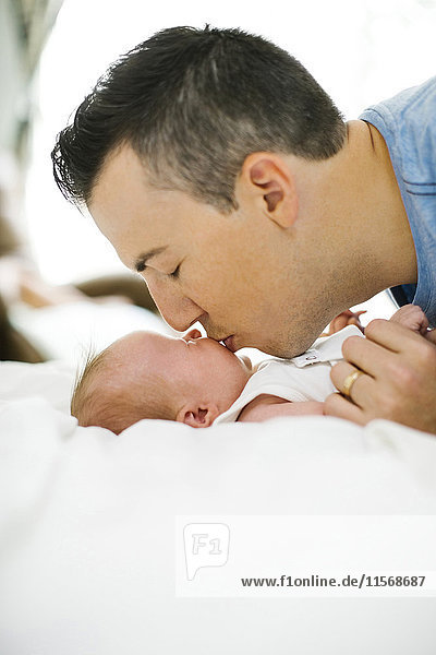 Vater küsst Tochter (0-1 Monate)