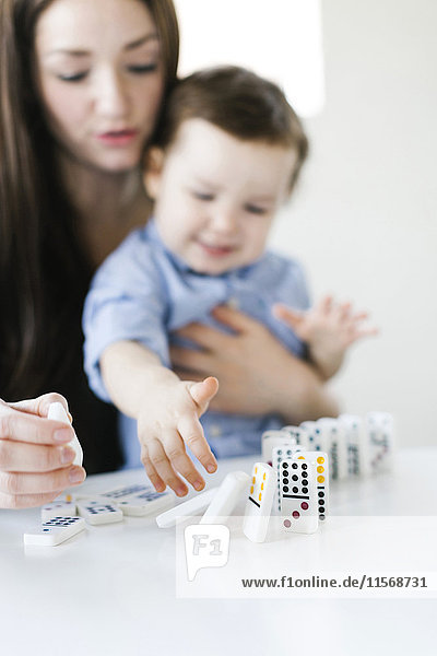 Mother playing domino game with son (4-5)