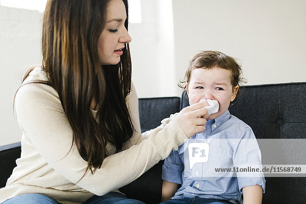 Mother helping son (4-5) blow nose