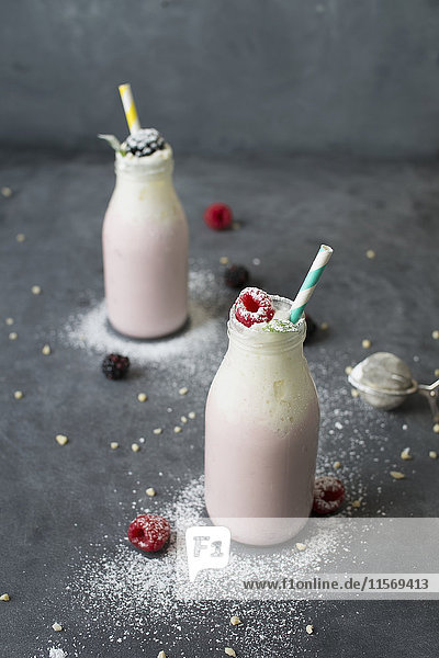 Studio shot of raspberry milkshake in bottles