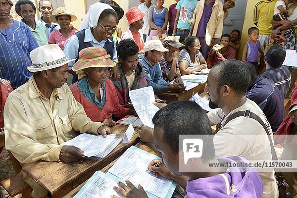 Dorfbewohner füllen auf dem Dorfplatz Anträge auf Zertifizierung ihres Landes aus  Dorf Analakely  Gemeinde Tanambao  Bezirk Tsiroanomandidy  Region Bongolava  Madagaskar  Afrika