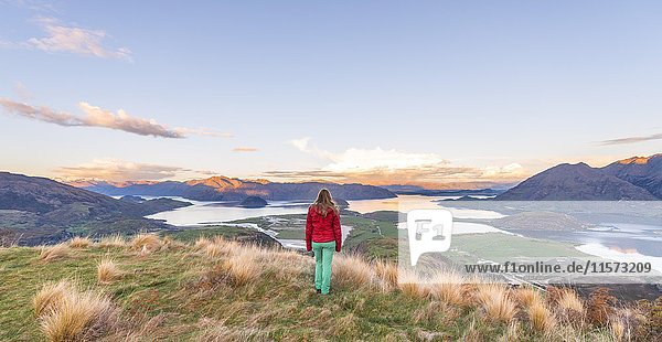 Wanderer mit Blick auf Lake Wanaka und Berge  Sonnenuntergang  Rocky Peak  Glendhu Bay  Otago  Southland  Neuseeland  Ozeanien