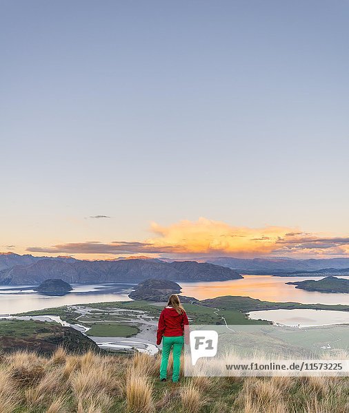 Wanderer mit Blick auf Lake Wanaka und Berge  Sonnenuntergang  Rocky Peak  Glendhu Bay  Otago  Southland  Neuseeland  Ozeanien