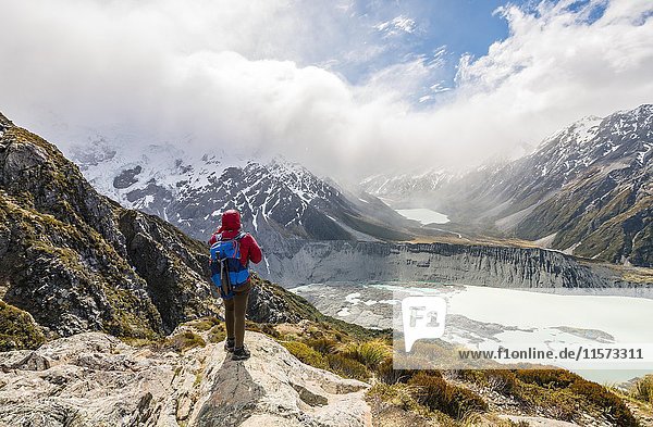 Hiker standing on rocks  view into the Hooker Valley from Sealy Tarns Track  glacial lakes Mueller Lake and Hooker Lake  Mount Cook National Park  Canterbury Region  South Island  New Zealand  Oceania