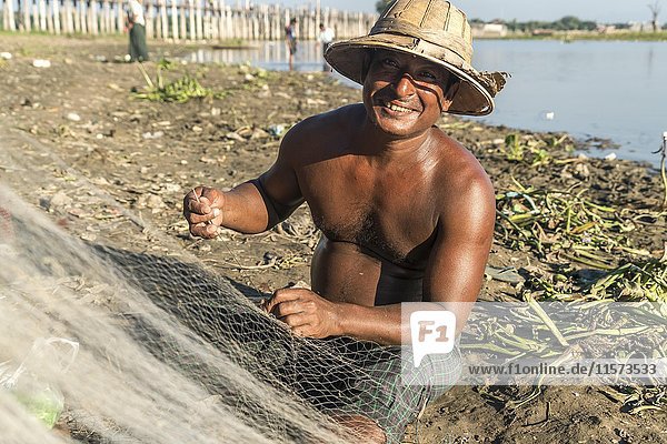 Fischer flickt sein Netz Taungthaman See  Amarapura  Mandalay  Myanmar  Asien
