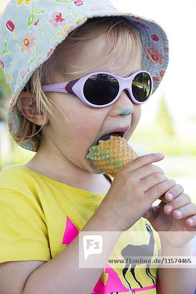 Toddler with sunglasses licking ice cream  Germany  Europe