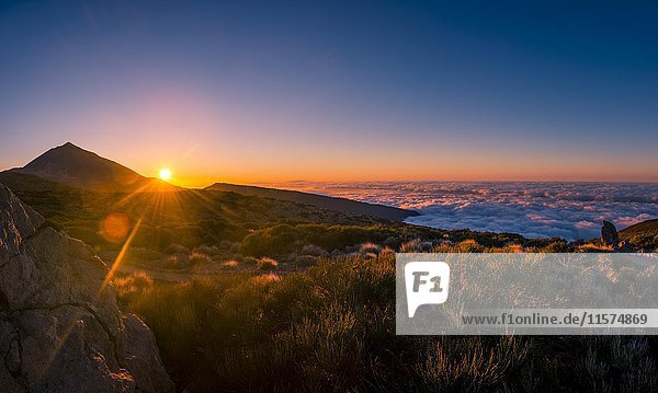 Sonnenuntergang  Sonnenuntergangsglühen  bewölkter Himmel  Vulkan Teide und Vulkanlandschaft  beleuchtete Landschaft  Nationalpark El Teide  Teneriffa  Kanarische Inseln  Spanien  Europa