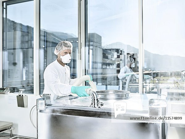Chemisches Labor  Chemiker mit Haarnetz und Gesichtsmaske in einer pharmazeutischen Produktion  Österreich  Europa