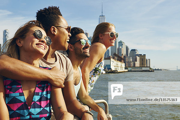 Vier erwachsene Freunde  die von der Uferpromenade des Flusses hinausblicken  New York  USA