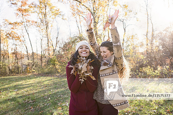 Zwei junge Frauen mit Herbstblättern
