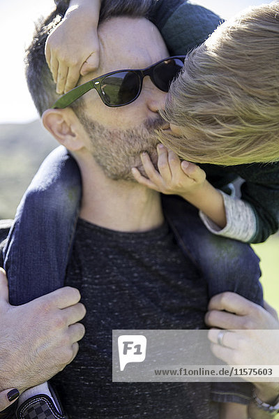 Junge beugt sich vor  um Vater zu küssen
