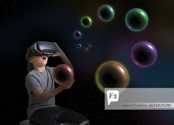 Junge mit Virtual-Reality-Headset  hält den Planeten in der Hand  digitales Komposit
