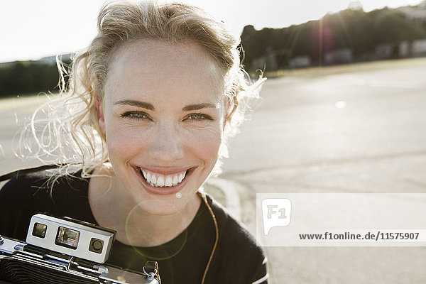Portrait of happy mid adult woman with vintage camera