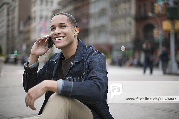 Young man in street  using smartphone  Manhattan  New York  USA