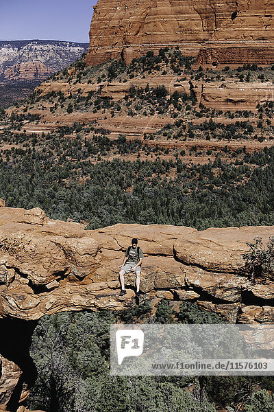 Man sitting on Devil's Bridge Sedona Arizona USA