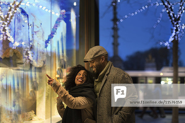Couple window shopping in city at night  New York  USA