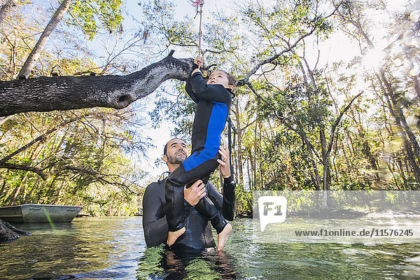 Vater im Fluss hilft Tochter mit Seilschaukel am Baum  Chassahowitzka  Florida  USA