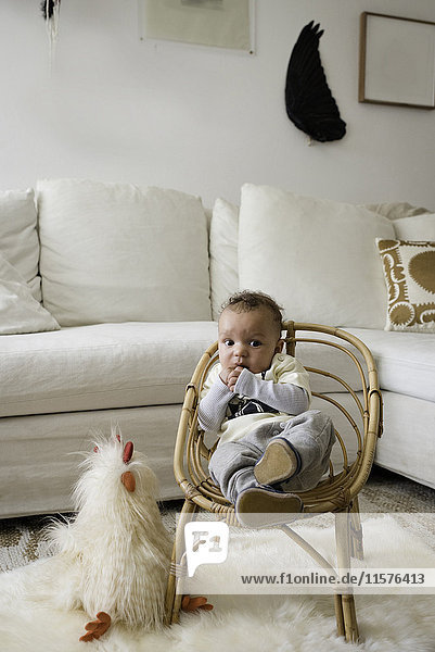 Portrait of baby boy sitting in wicker chair