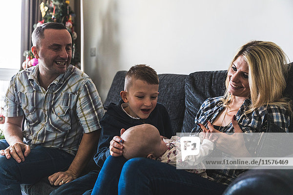 Family sitting on sofa young baby on mother's lap