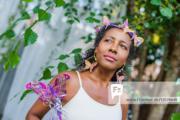 Porträt einer reifen Frau mit Schmetterlingen im Haar