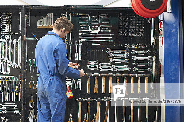 College-Mechanikstudent wählt Schraubenschlüssel aus Werkstatt-Werkzeugsatz