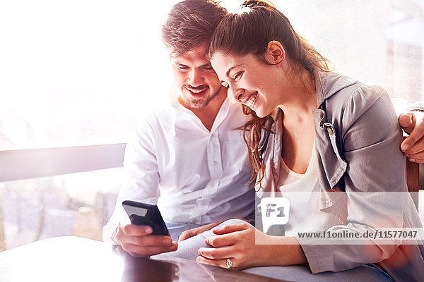 Businessman and woman looking at smartphone in office
