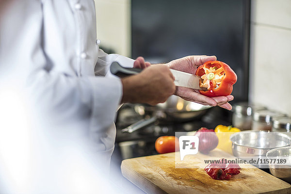 Chefkoch entkernt rote Paprika mit dem Messer