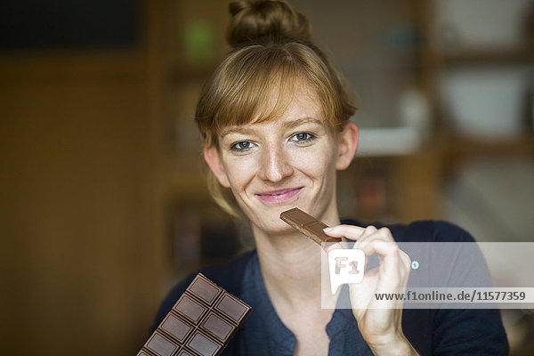 Porträt einer jungen Frau  die Schokolade isst
