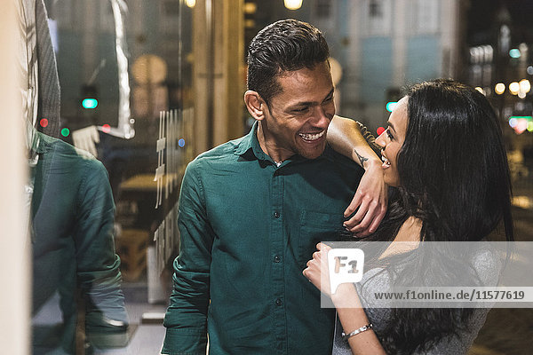 Couple in city at night face to face smiling