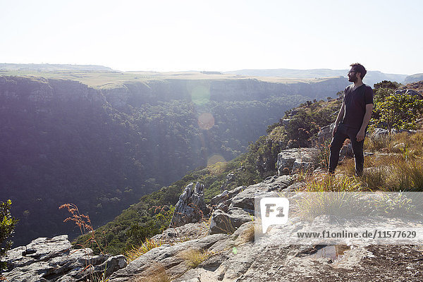 Man standing on mountain top  looking at view  South Africa