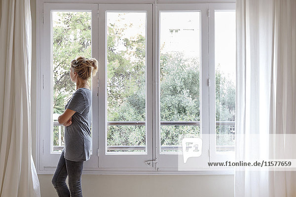 Woman at home  looking out of window