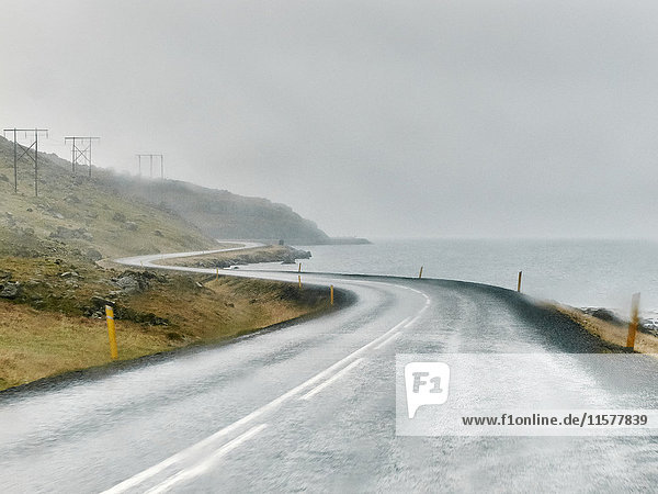 Wet winding coastal road  Hof  Iceland