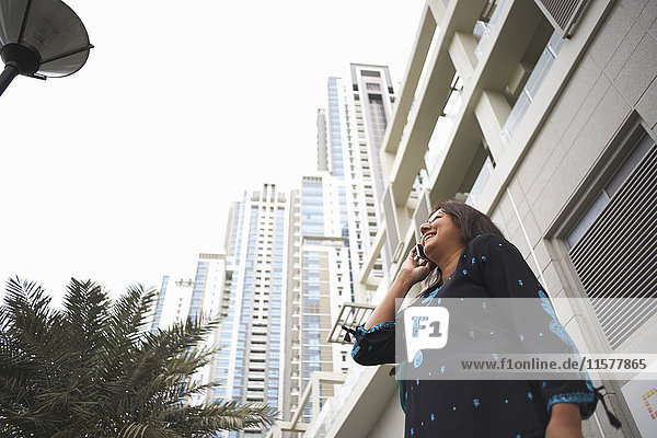 Niedriger Blickwinkel einer reifen Geschäftsfrau beim Smartphone-Anruf  Dubai  Vereinigte Arabische Emirate