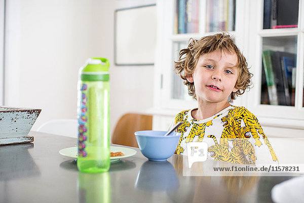 Porträt eines Jungen beim Frühstück am Küchentisch
