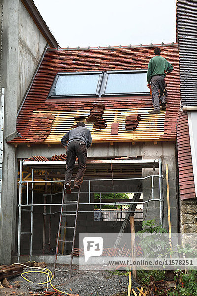 Frankreich Hausbau  Sicherheit auf einem Gerüst  Dachdecker beim Bau eines Daches