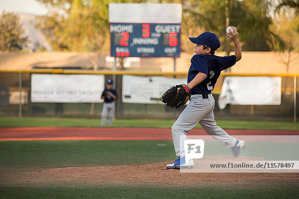Jungen-Baseball-Werfer  der den Ball auf das Baseballfeld wirft