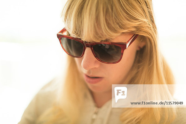 Blonde Frau mit Sonnenbrille mit Blick nach unten