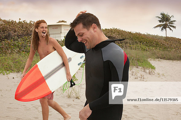 Männlicher Rettungsschwimmer unterhält sich mit Surfer am Strand