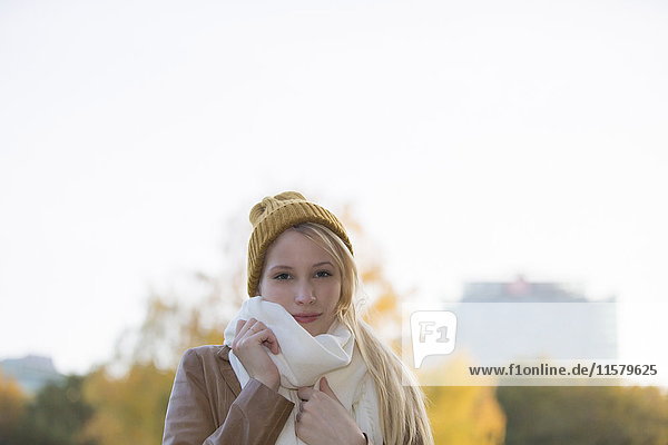Porträt einer hübschen blonden Frau mit Mütze und Schal im Herbst