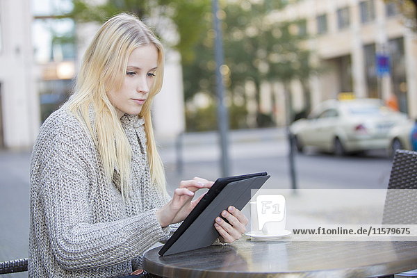 Pretty young woman with tablet in a Cafe in city center